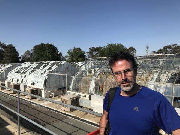 Scientist standing in front of shattered research glasshouses