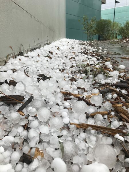 Large hailstones piled up against the wall