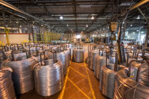 Bales of silver rust resistant fencing sitting in a warehouse