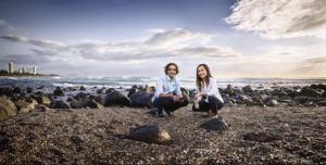 Man and woman squatting on a beach